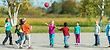children playing with a ball outside on a sunny day back to school after covid-19