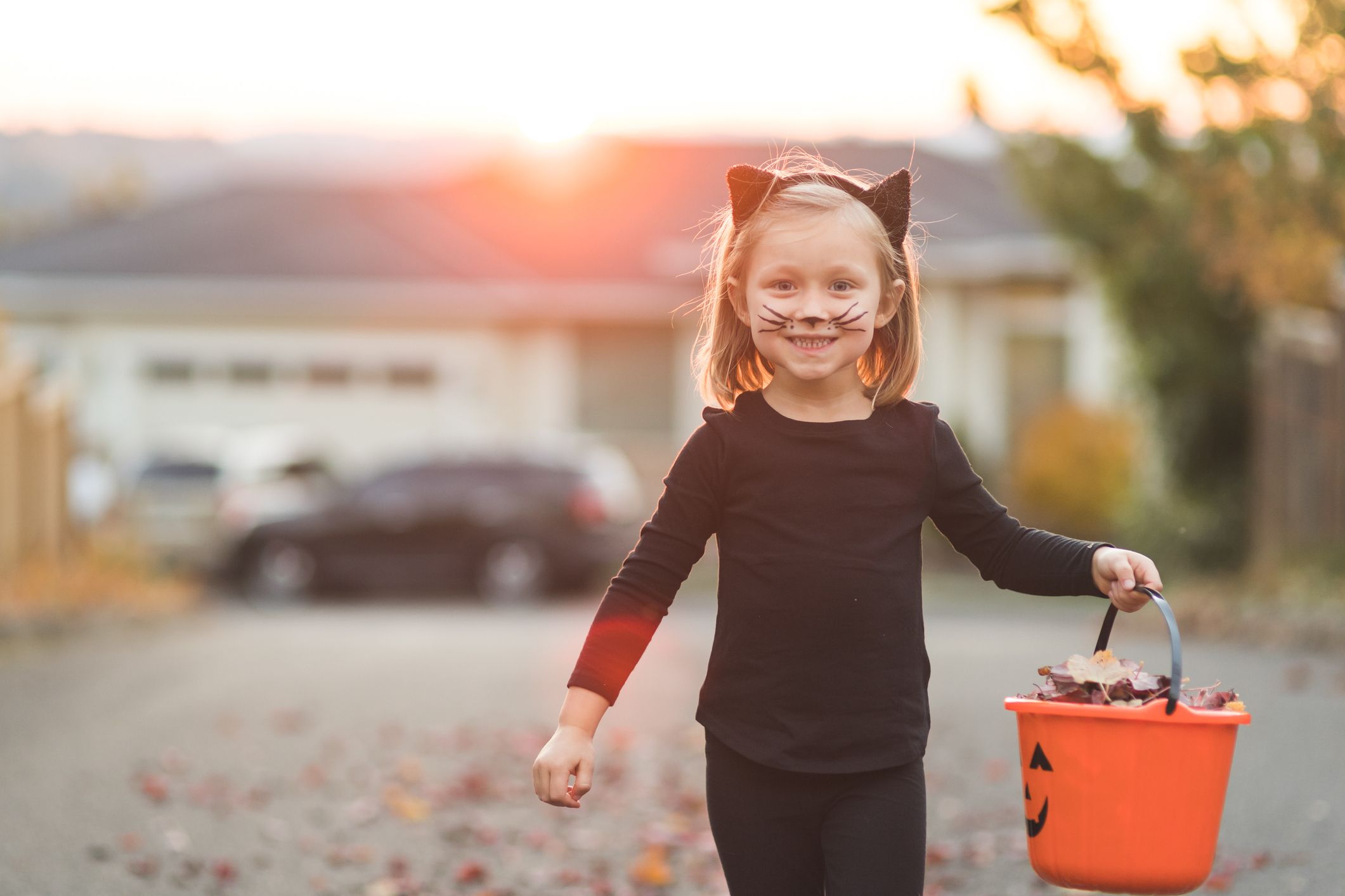 girl dressed as black cat for halloween with candy basket