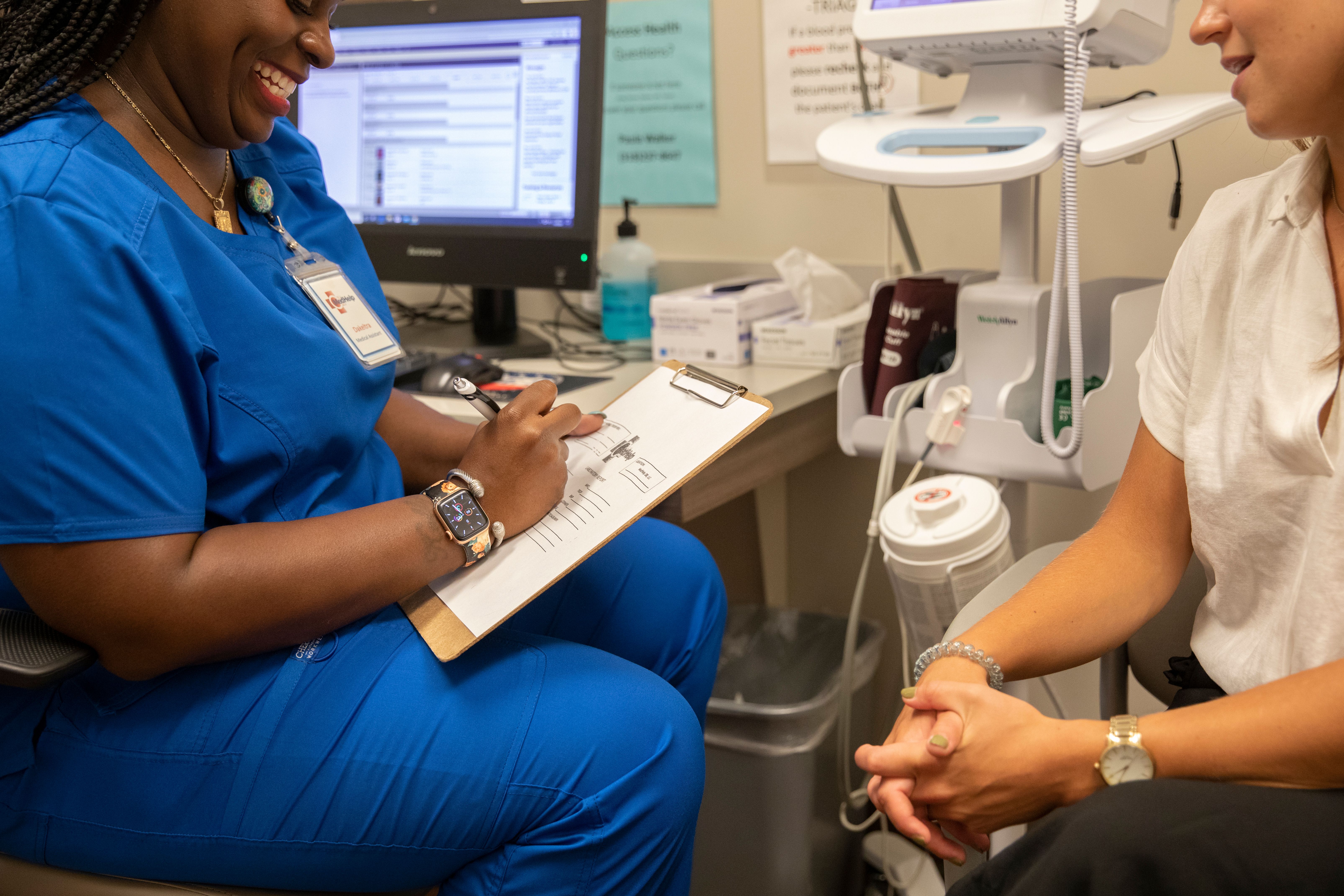 Nurse taking vital signs with patient at medhelp