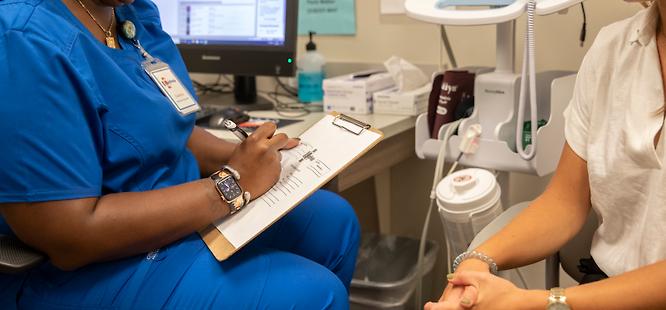 Nurse taking vital signs with patient at medhelp