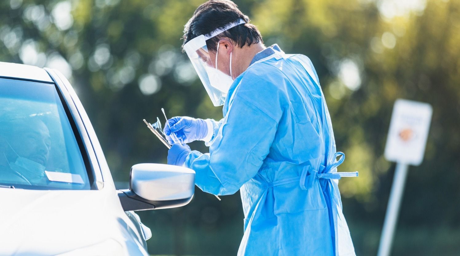 male nurse getting ready to give a drive up test for covid-19 at medhelp urgent care