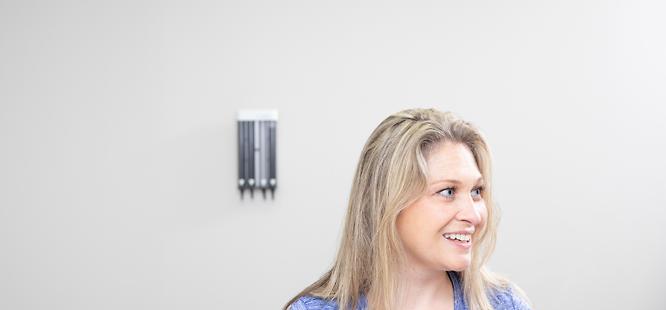 female patient wearing a blue shirt sitting a safe exam room at medhelp urgent care