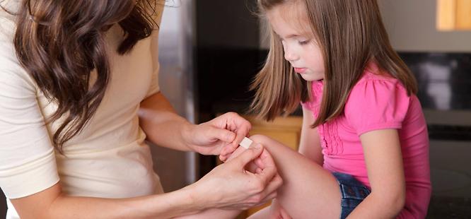 Mom using first aid kit at home