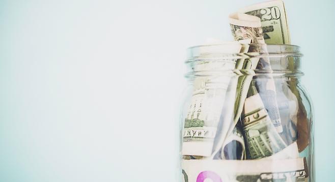 glass jar of cash saved going to urgent care instead of the er