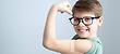 Child wearing glasses showing arm after vaccine