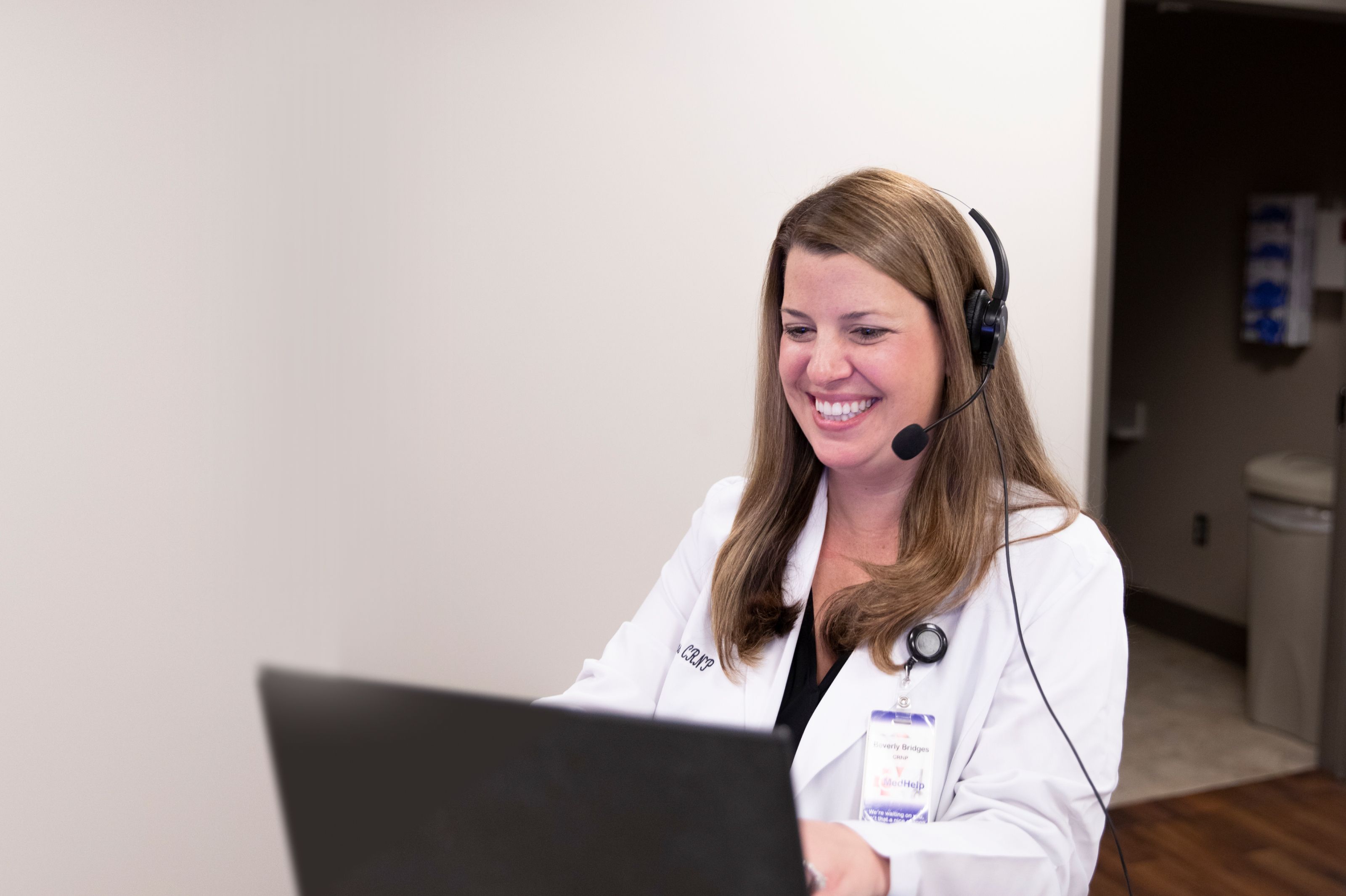 nurse practitioner wearing headset providing online telehealth virtual doctor visit