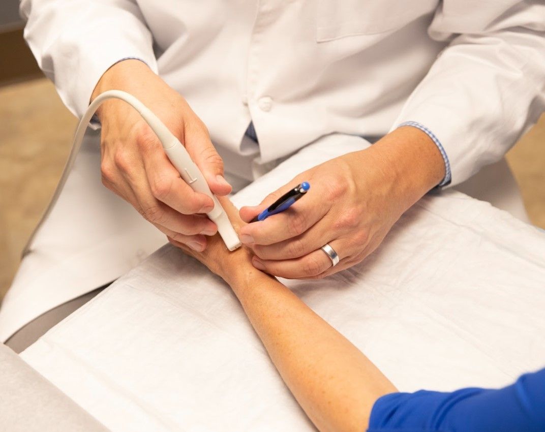 doctor performing procedure on a patient hand at medhelp urgent care