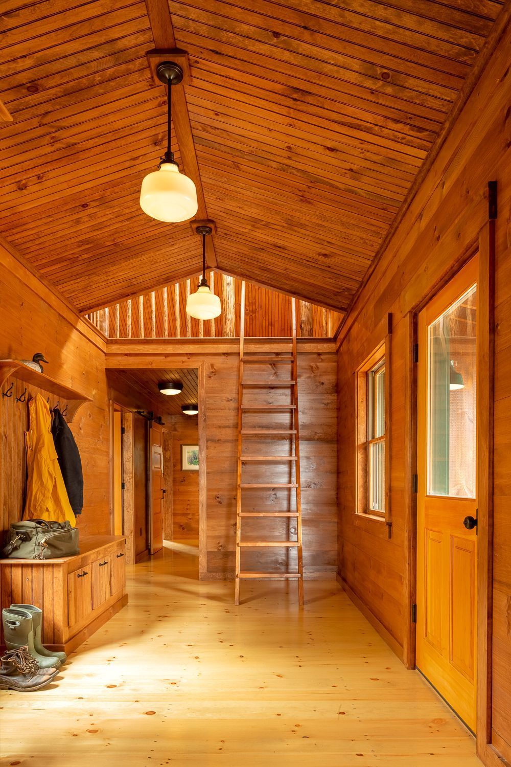 Custom entry bench with storage and custom loft ladder at Breakwater Lodge